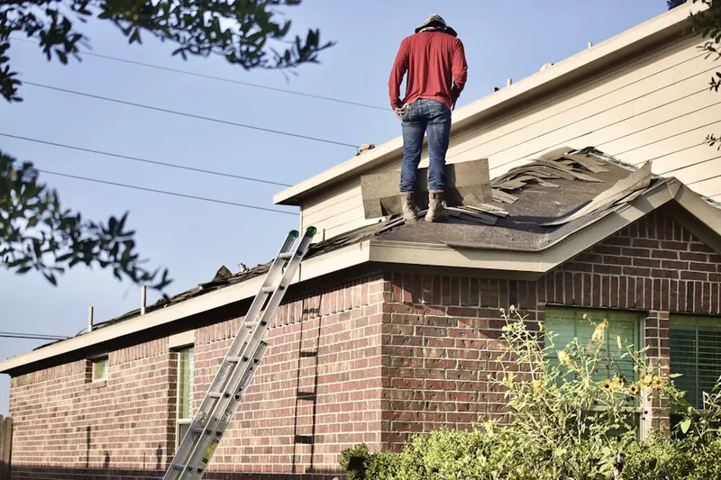 Professional roofer working on a residential roof in Agganis AC